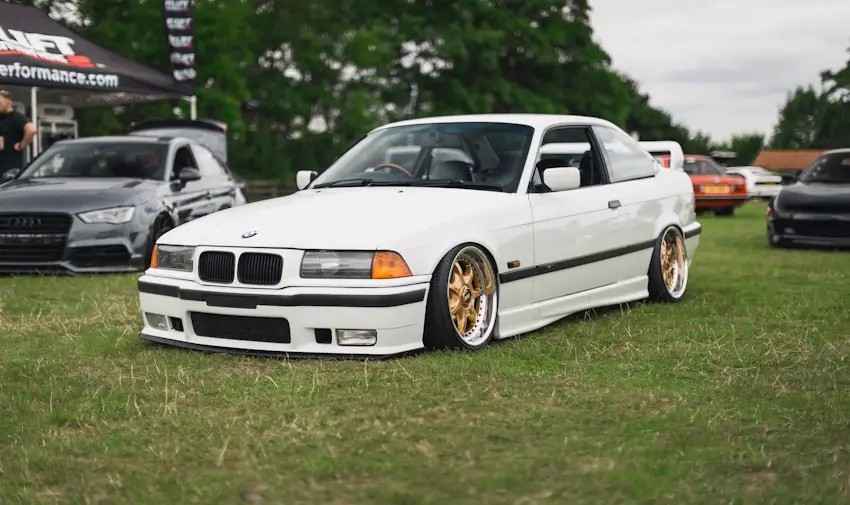 suspension content image - white lowered BMW parked on grass