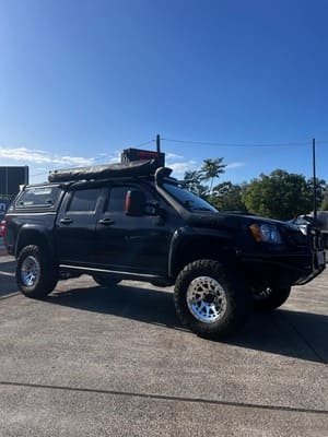  Black Holden Colorado with snorkel, canopy, roof rack and off-road setup.