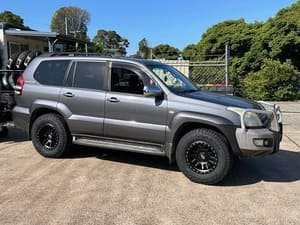  Grey Toyota Prado 120 Series with black ROH wheels and all-terrain tyres.