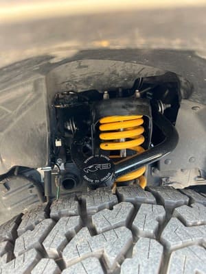  Detail of front suspension upgrade showing yellow coil spring and upper control arm.