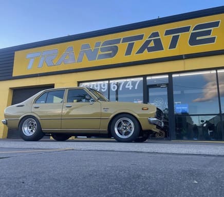Classic gold sedan parked outside the Transtate workshop 